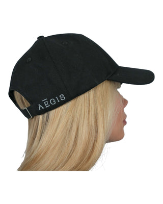 Profile view of a person wearing a black baseball cap embroidered with the text 'AEGIS' on the side, designed as part of an EMF (Electromagnetic Field) apparel line.