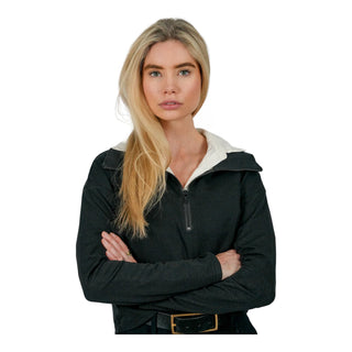 A confident woman with long blonde hair, wearing a black EMF protective hoodie with a white collar, stands with her arms crossed, showcasing the practical and stylish design of the electromagnetic field apparel.